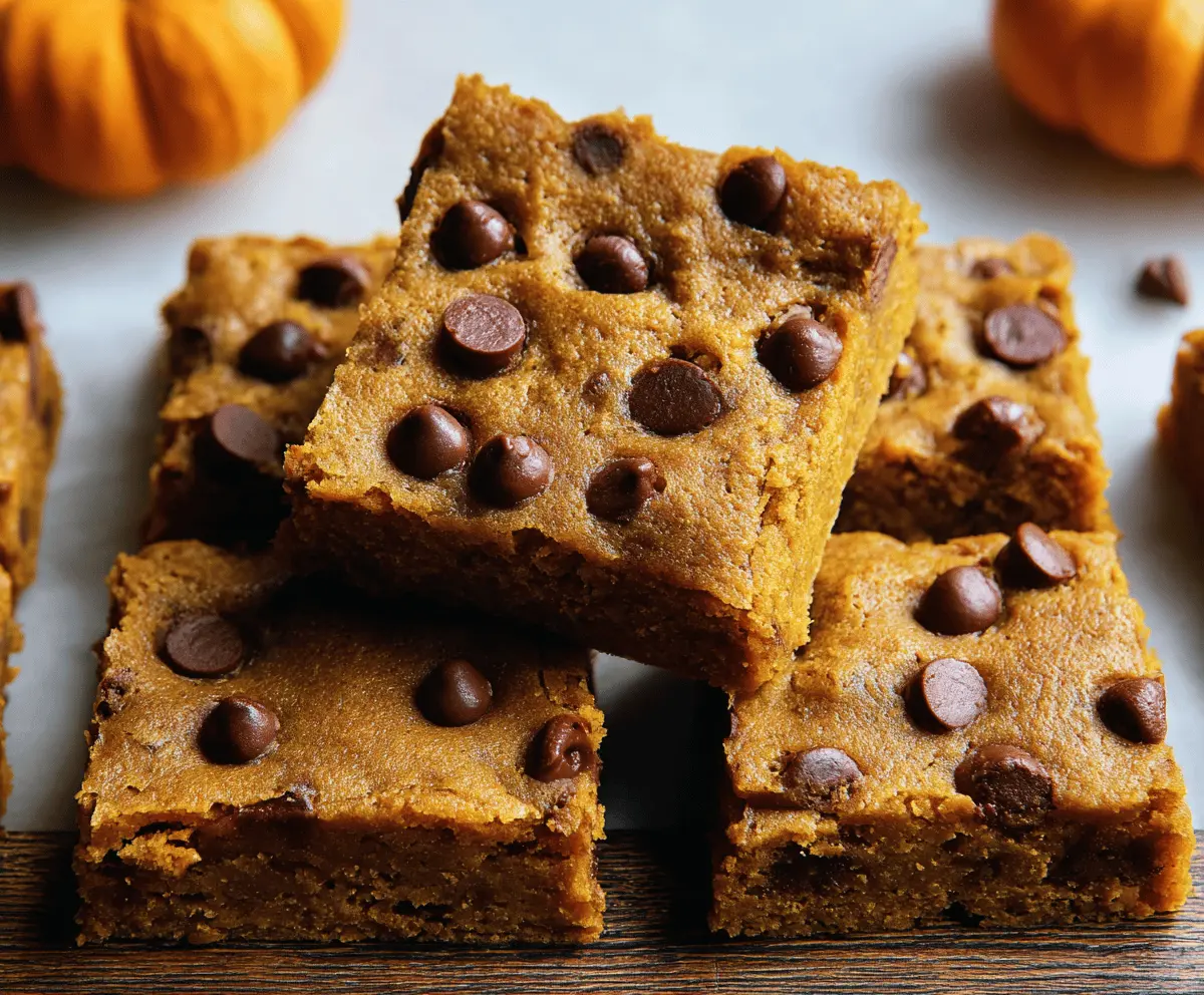 Delicious homemade pumpkin chocolate chip bars topped with melted chocolate chips and a sprinkle of cinnamon, perfect for fall desserts.