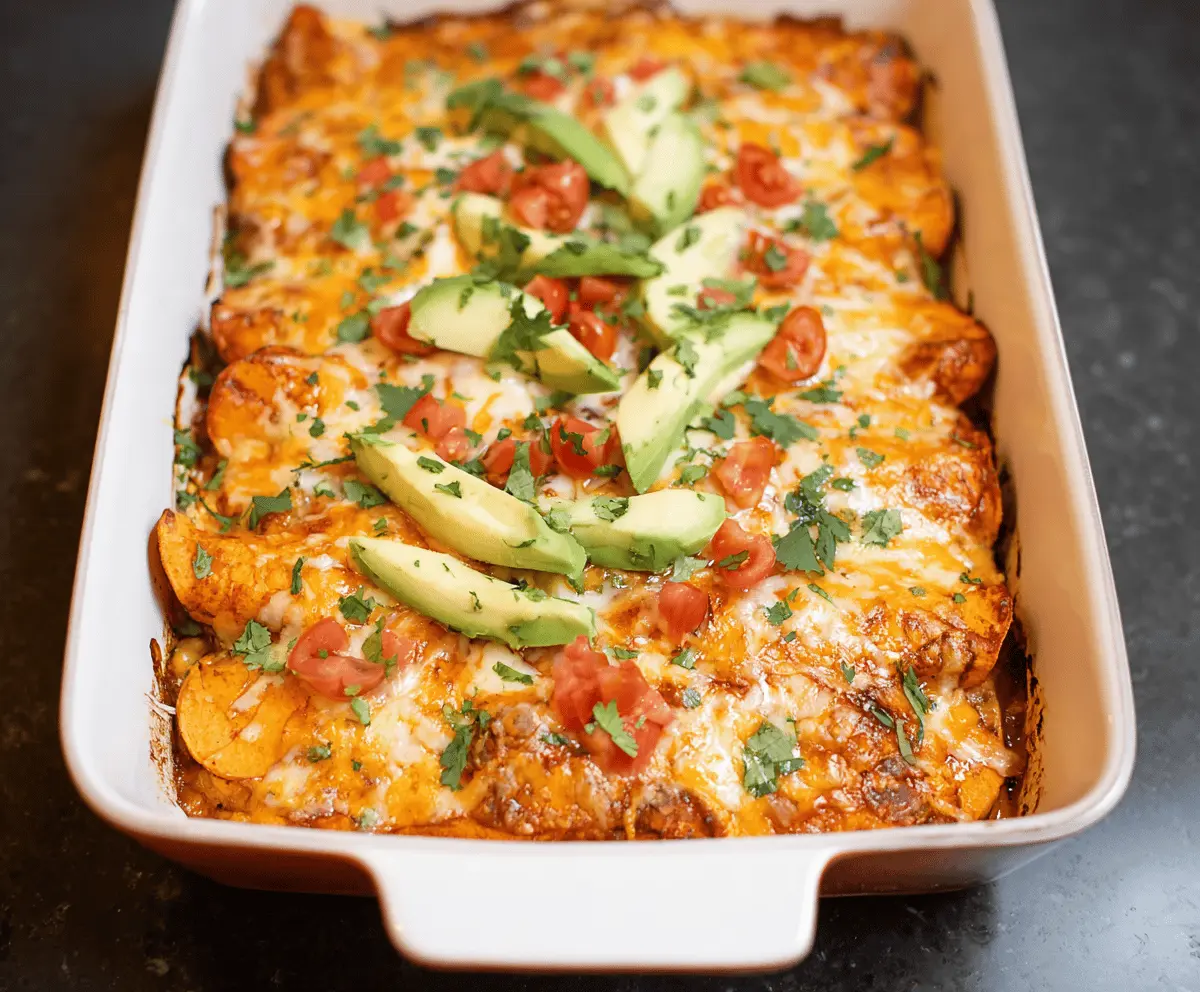 Delicious sweet potato chicken enchiladas topped with melted cheese on a serving plate.