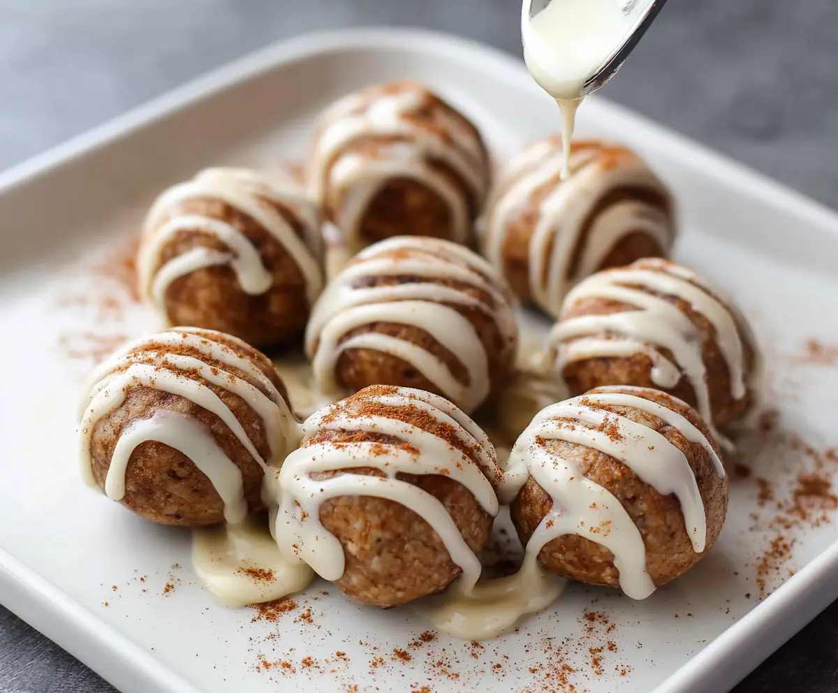Delicious cinnamon roll protein bites on a white plate, perfect for a healthy snack.