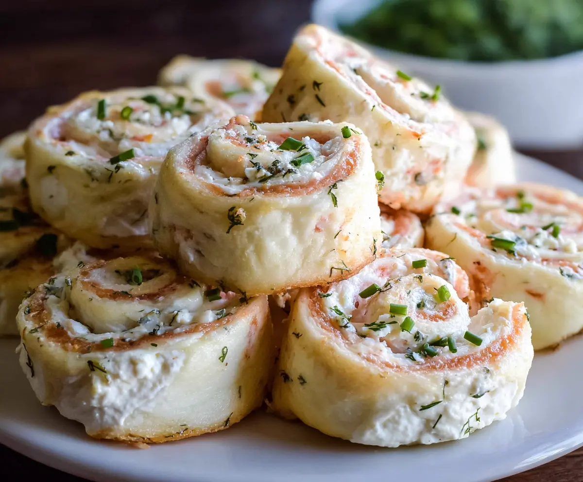 Savory cream cheese pinwheels with flaky pastry and colorful fillings on a wooden board