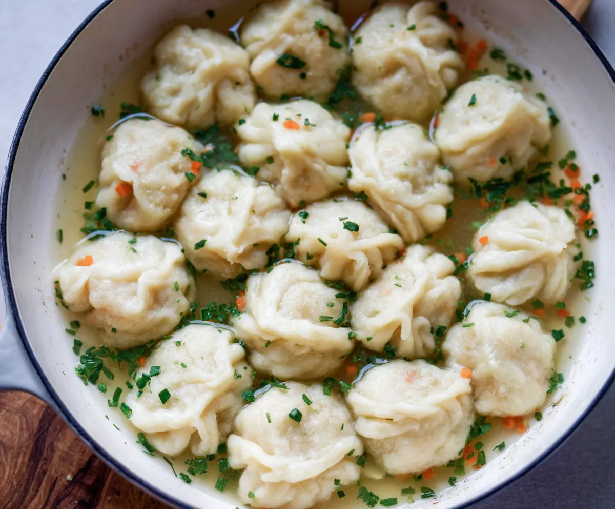 Delicious sourdough discard dumplings served with fresh herbs on a rustic plate