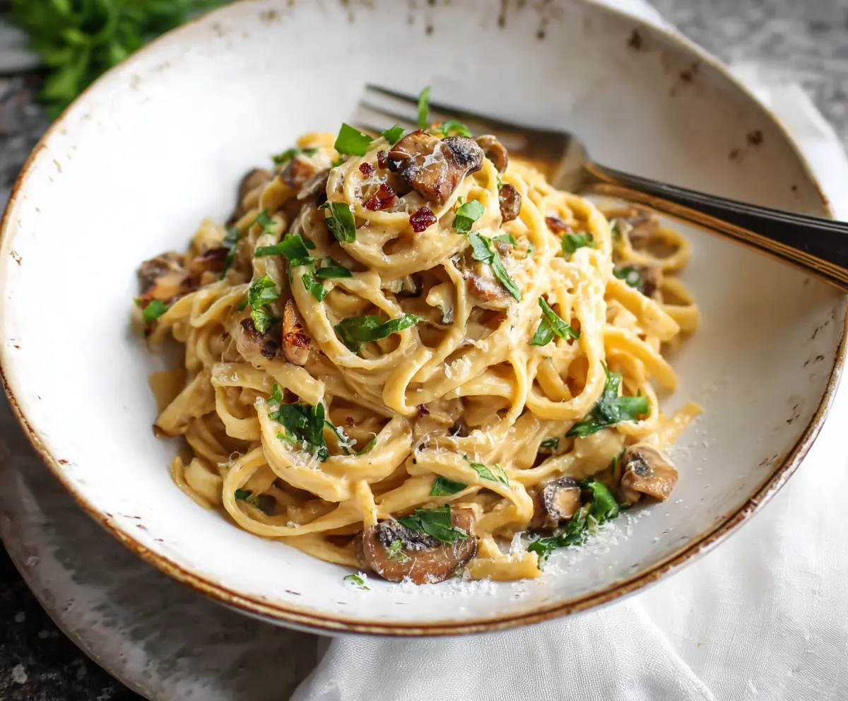 Delicious Miso Butter Pasta served with fresh herbs on a wooden table.