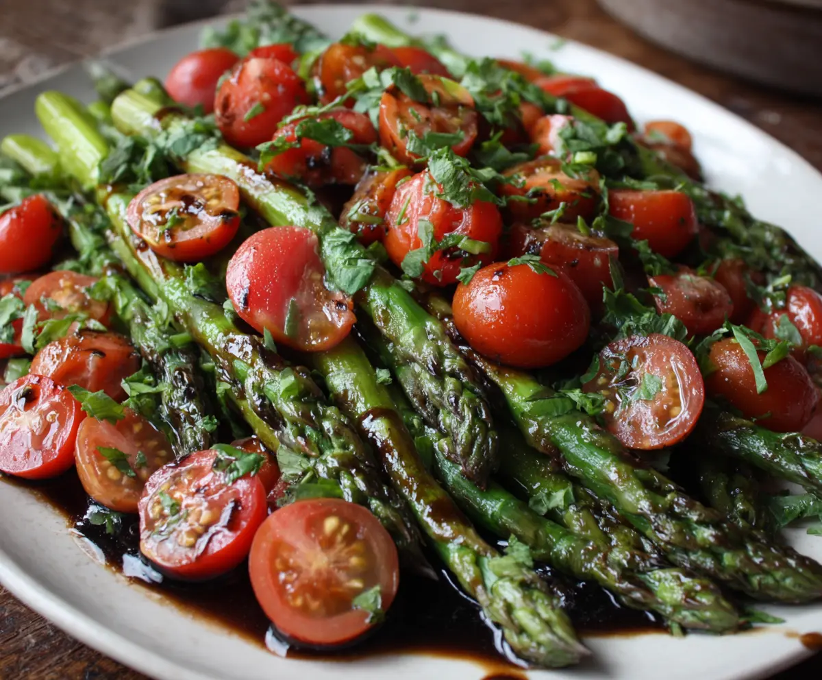 Fresh balsamic asparagus and tomato salad garnished with herbs, perfect for a healthy appetizer or side dish.