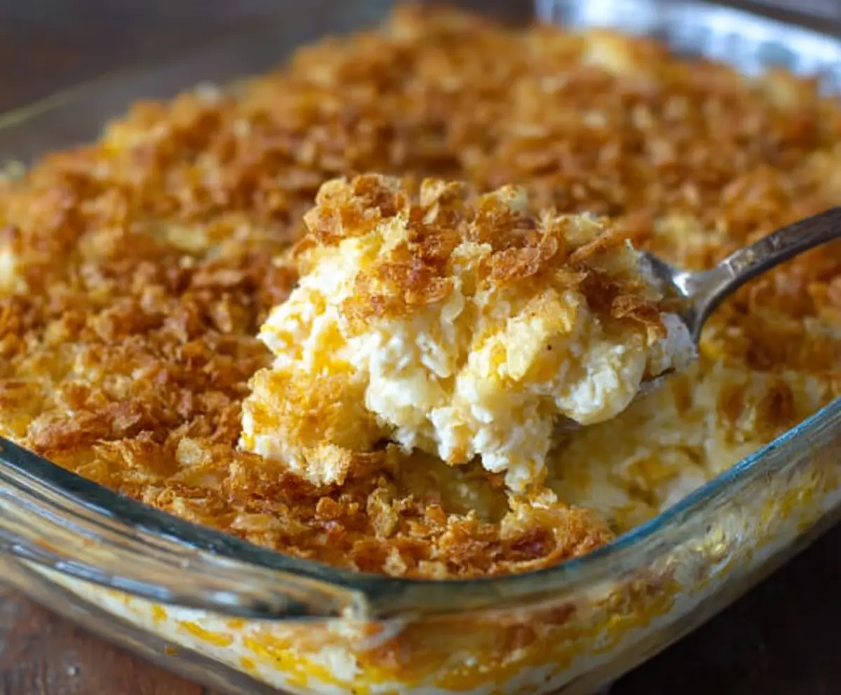 Delicious cheesy funeral potatoes casserole topped with melted cheese and crispy potato bits.