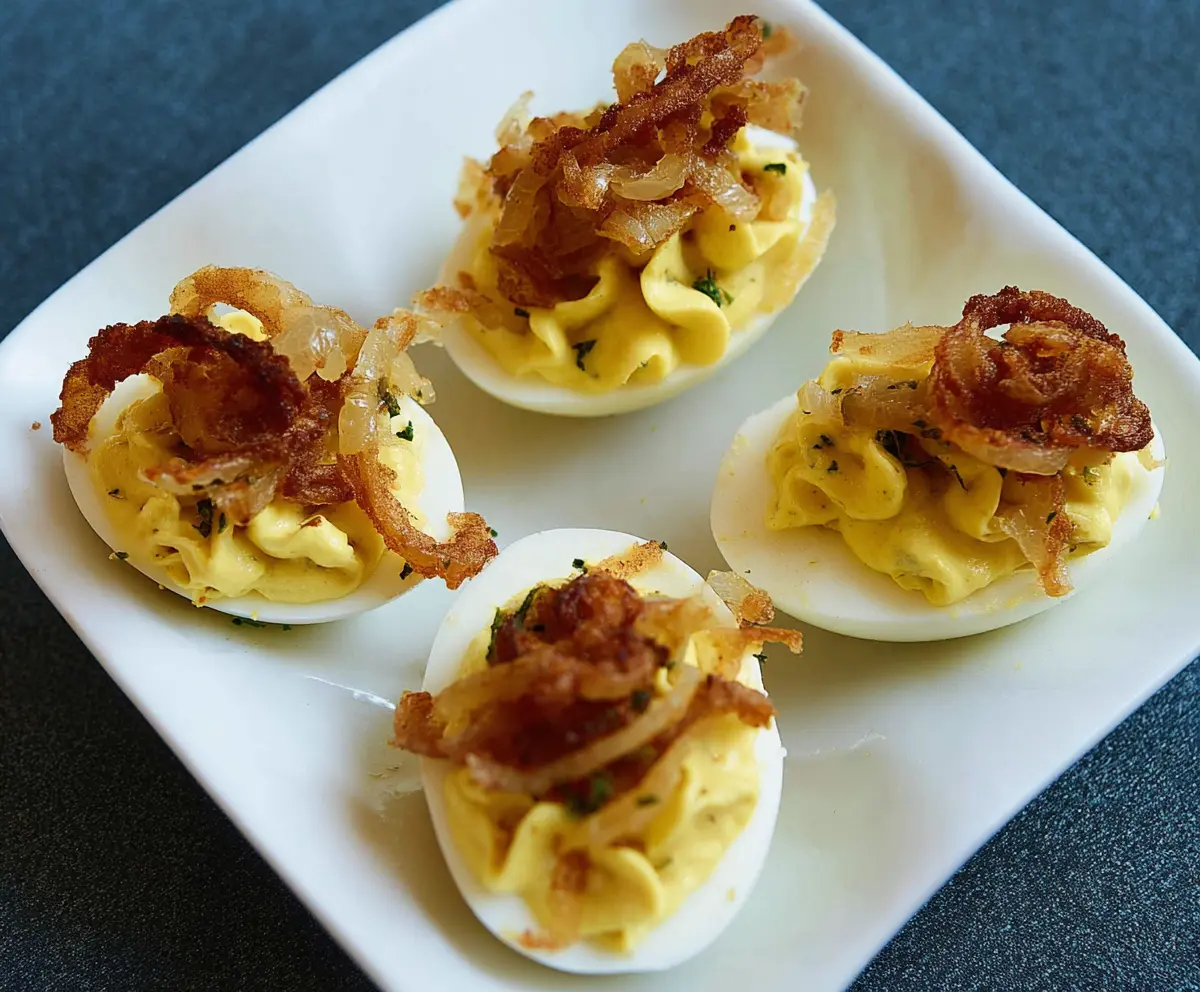 French Onion Deviled Eggs with caramelized onions and creamy filling on a serving plate